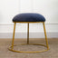 Dark blue round stool with gold metallic base and upholstered seat
