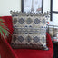 Grey cotton cushion cover with side pom-poms and embroidery