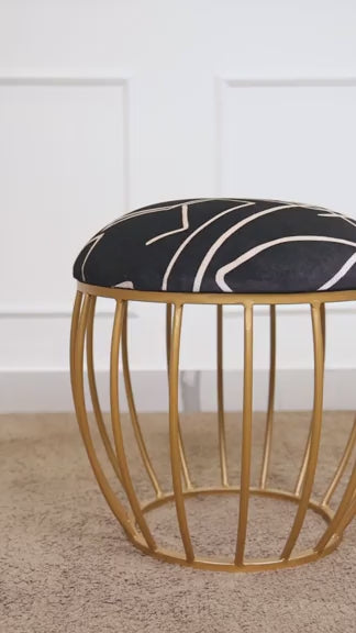 Black abstract fabric stool with a gold cage-style metallic base
